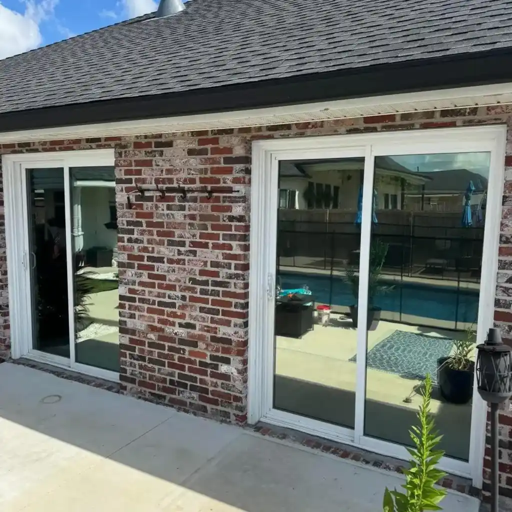 Brick home with tinted sliding glass doors after residential window tinting in Houma, LA