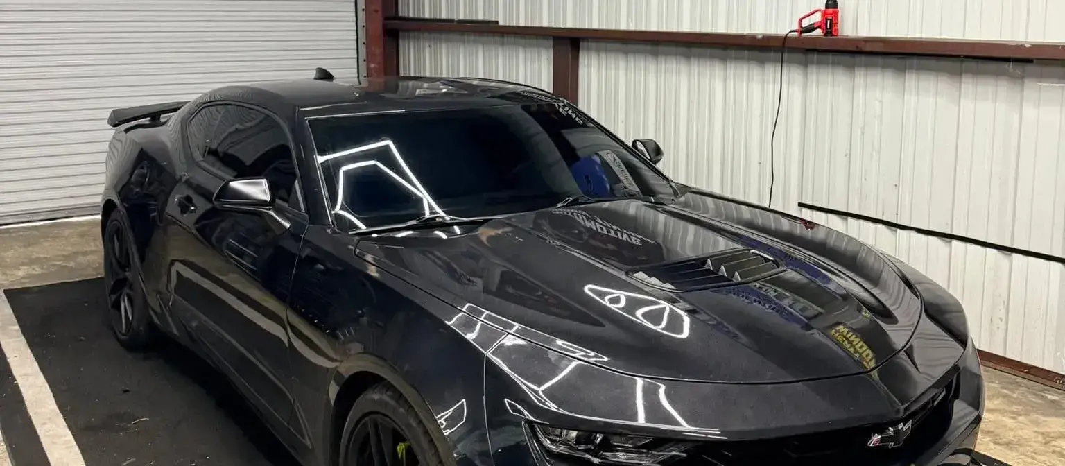 Black Camaro with window tint inside the South Side Detail And Tint shop in Houma, LA