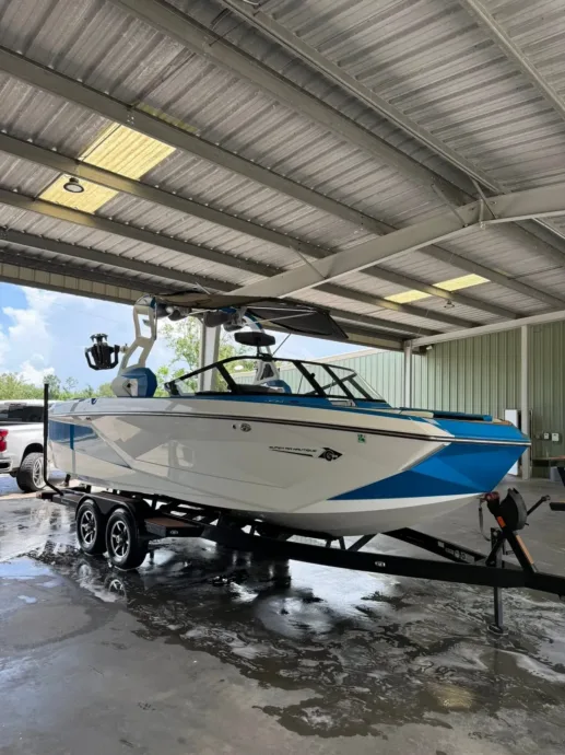 Wake boat on a trailer under the shop canopy in Houma