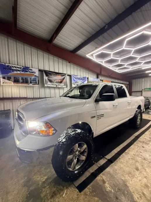 Lifted white Ram truck inside the South Side Detail And Tint shop in Houma, LA