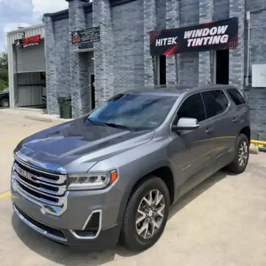 Gray GMC Acadia with window tint in front of the HITEK sign in Houma, LA