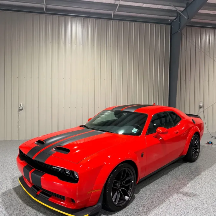 Red Dodge Challenger inside the locally owned tint and detailing shop at 6031 W Main St in Houma, LA